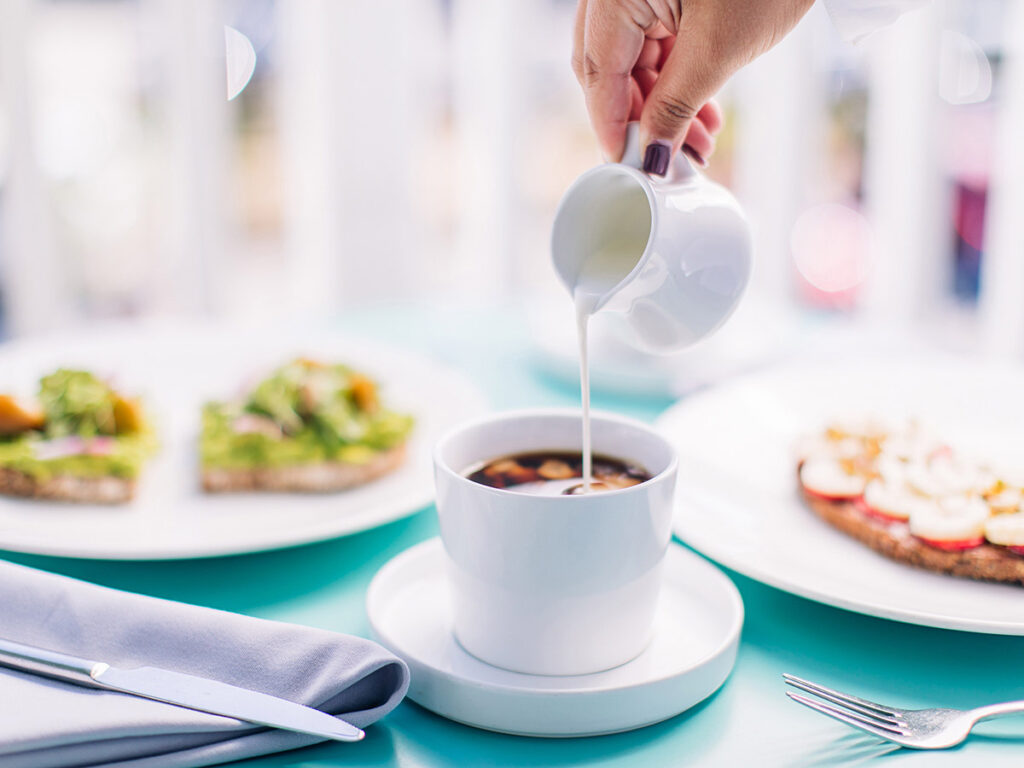 outdoor table with plate of breakfast and drinks